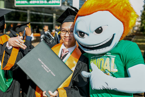 Bachelor of Science in Business Analytics graduate from the Naveen Jindal School of Management with Temoc, the UT Dallas mascot