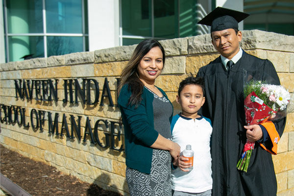 Bachelor's in Information Technology and Systems graduate with his family on UT Dallas commencement day