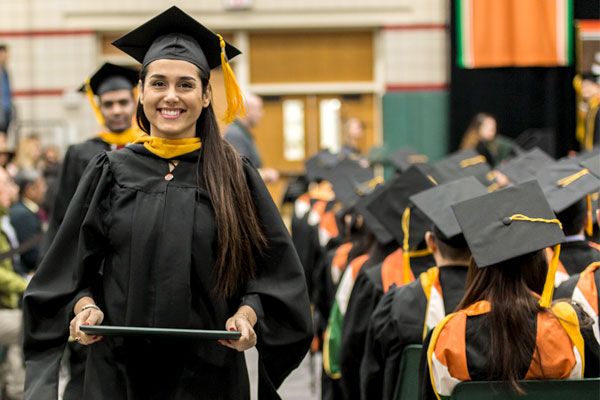 Ava Raeisi returns to her seat in the Activity Center during her commencement ceremony. She earned a master’s degree in business analytics.