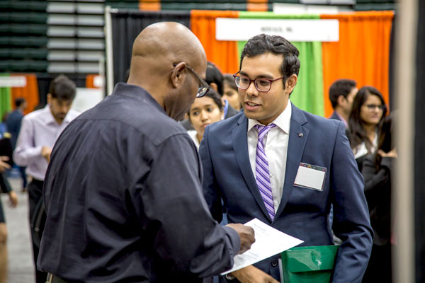 Master's in Information Technology Management student meeting with a recruiter at a UT Dallas career fair